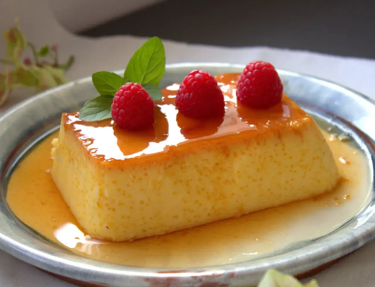 Delicioso flan de queso sin horno, cubierto con caramelo l&iacute;quido y adornado con frambuesas y menta fresca.
