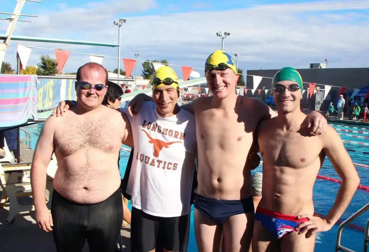 Vier Schwimmer posieren am Beckenrand. Sie sind bereit für ihr tägliches Schwimmen, vorher und nachher.