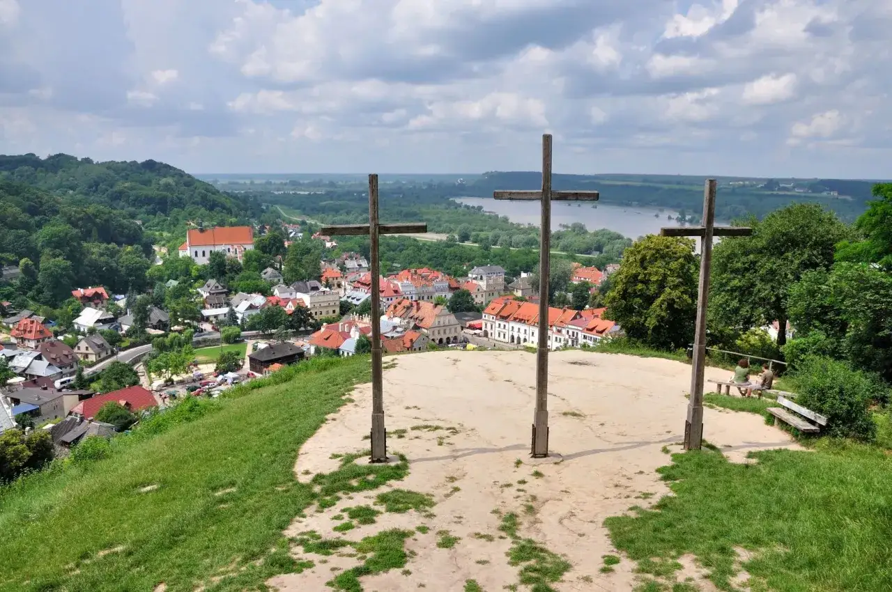 Trzy drewniane krzyże na wzgórzu górują nad miastem i rzeką. Widok z Góry Trzech Krzyży.