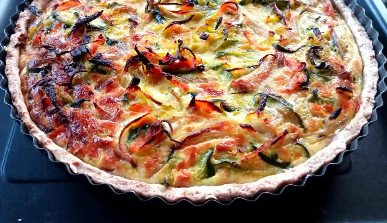 Torta salata estiva con verdure colorate e crosta dorata, un piatto perfetto per le giornate calde.