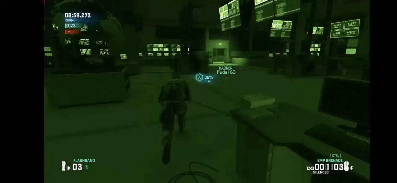 Gracz w grze Splinter Cell skrada się przez ciemne pomieszczenie pełne monitorów.