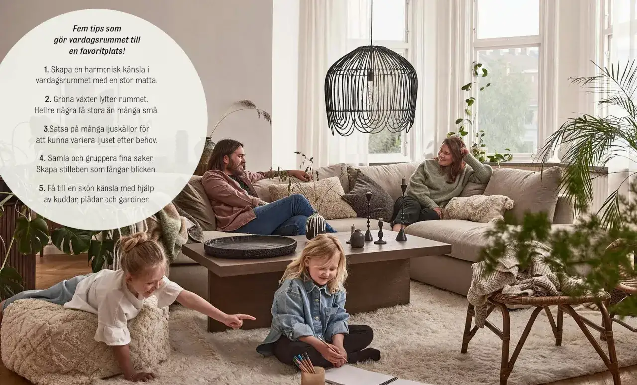 En familj njuter av en mysig stund i vardagsrummet. En stor, fluffig matta under matbordet barnen leker p&aring; skapar en varm och inbjudande atmosf&auml;r.