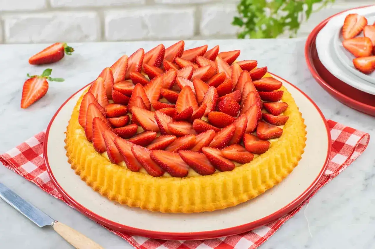Una deliziosa crostata morbida alle fragole, ricca di frutta fresca e crema, pronta per essere gustata.