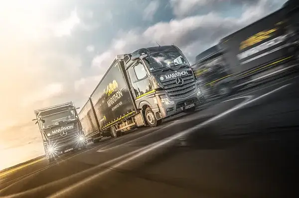 Dwa ciężarówki Marathon jadące drogą, realizując zlecenie transportowe.