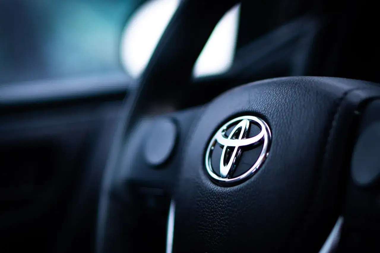 Logo Toyoty na kierownicy. Wnętrze samochodu, prawdopodobnie Toyota Auris 1.4 D4D, gotowe do jazdy.