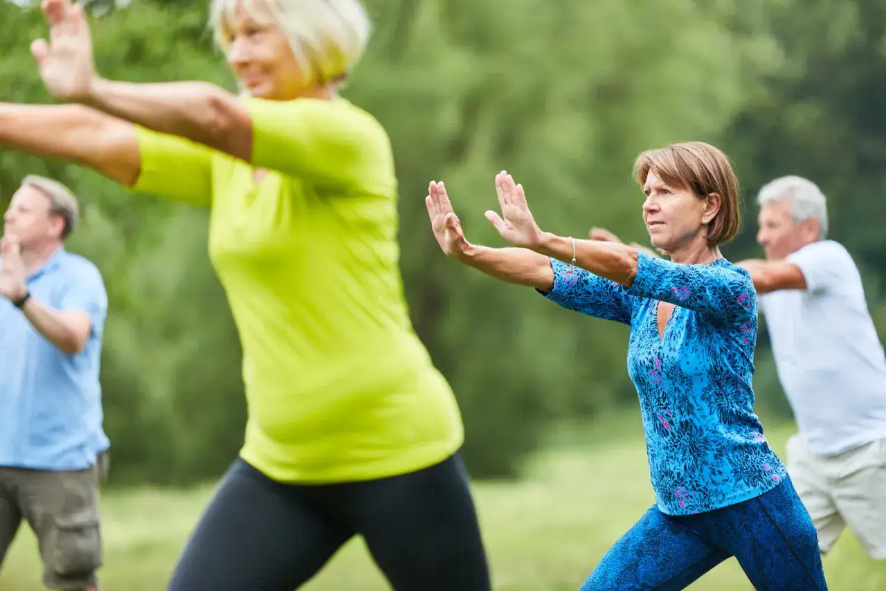 Des seniors pratiquent le Qi Gong en plein air, profitant des **18 mouvements Qi Gong bienfaits** pour leur bien-être.