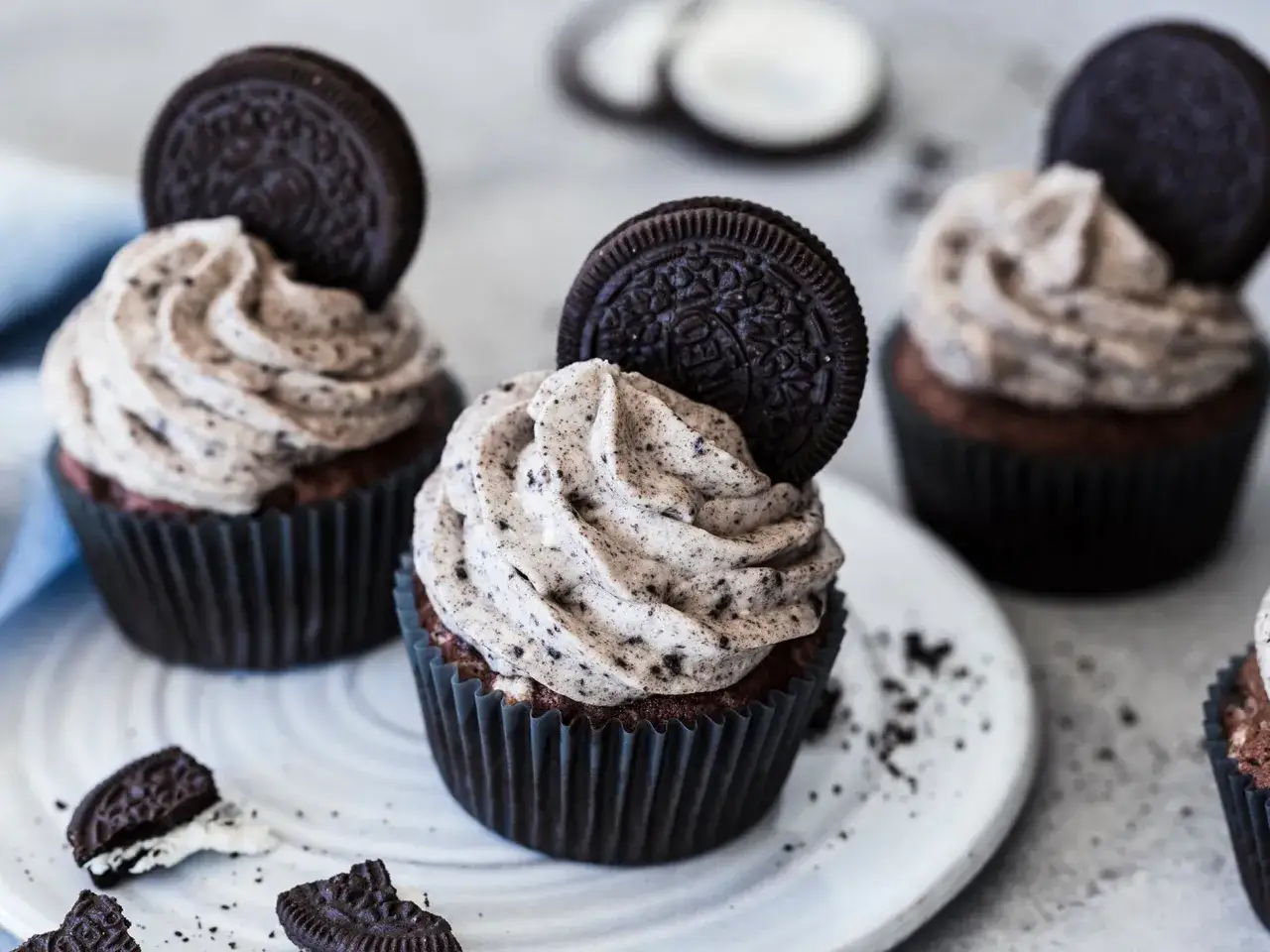 Drei leckere Oreo Muffins mit cremiger Füllung und einem ganzen Oreo-Keks obendrauf.