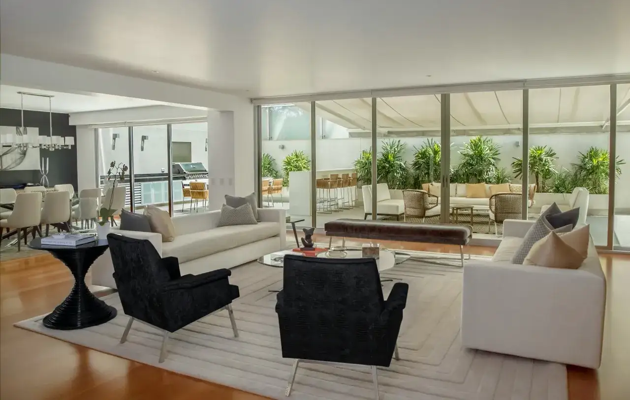 Modernes haus einrichten mit weißen Sofas, schwarzen Sesseln und einem Essbereich. Ein Blick in den Garten mit Sitzgelegenheiten.