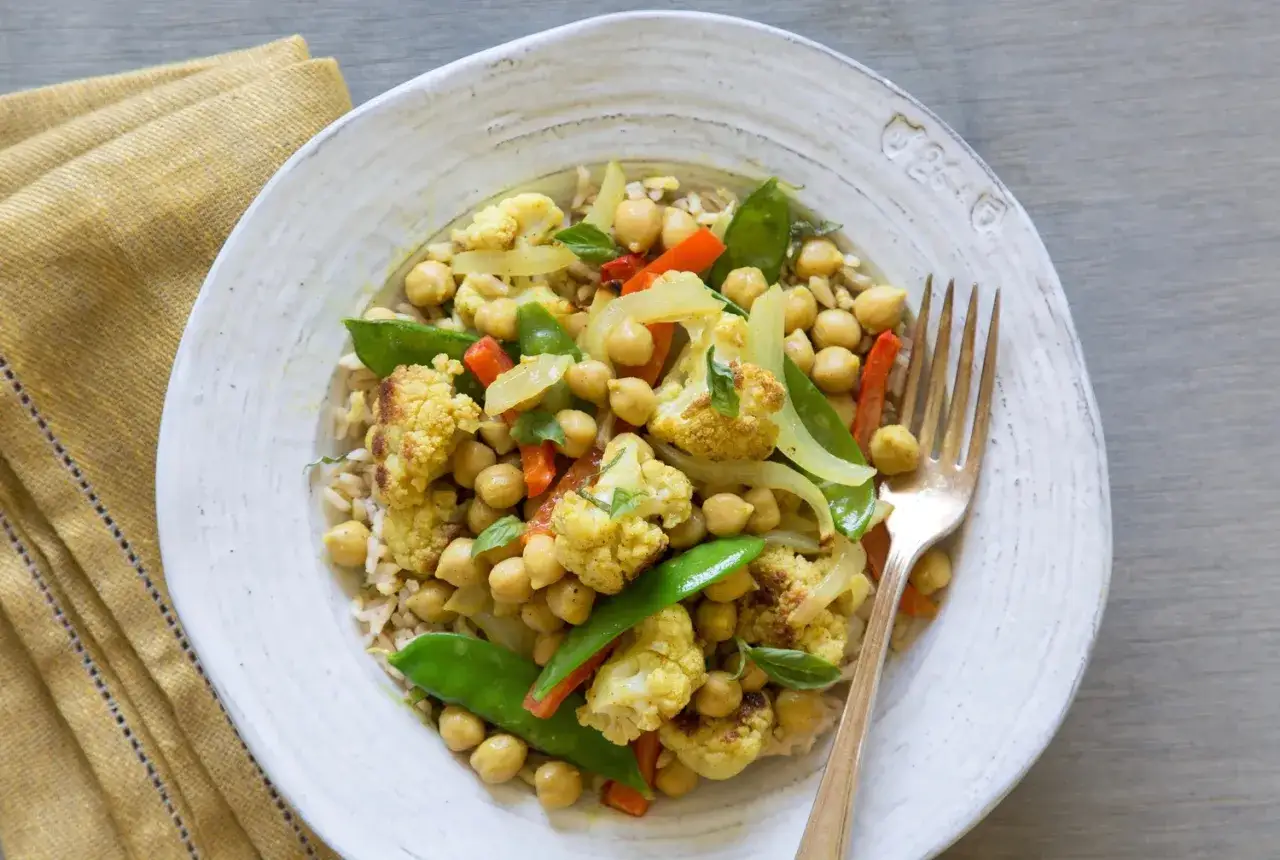 Ein köstliches Thai Curry Rezept mit Blumenkohl, Kichererbsen und Erbsen auf Reis.