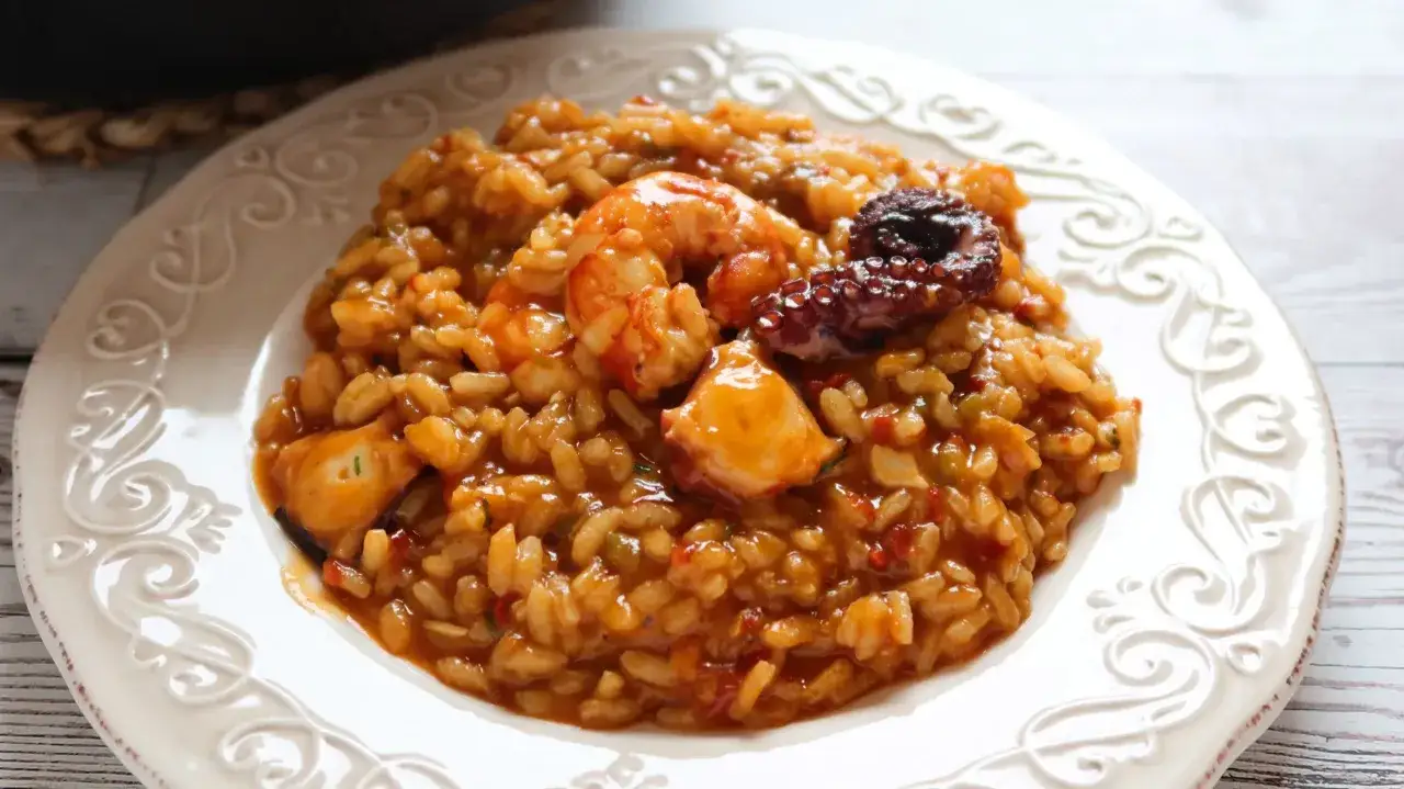 Arroz con gambones y pulpo, un plato de marisco delicioso y lleno de sabor, servido en una elegante vajilla.