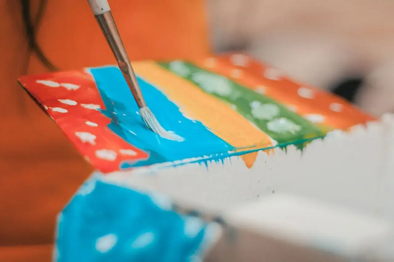 Une **aquarelle sur toile** prend vie avec des touches de pinceau bleues sur des bandes color&eacute;es.