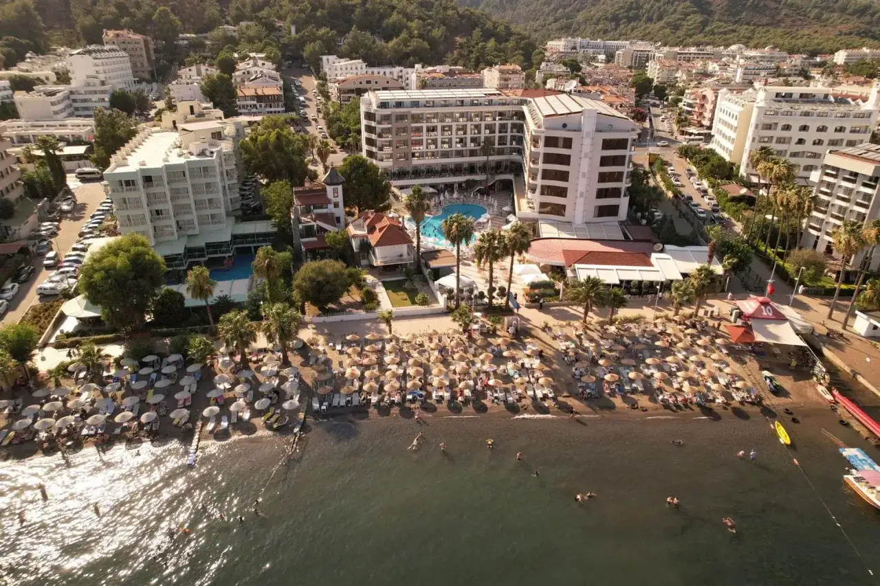 Widok z lotu ptaka na hotel przy plaży z leżakami i parasolami. Wiele pozytywnych