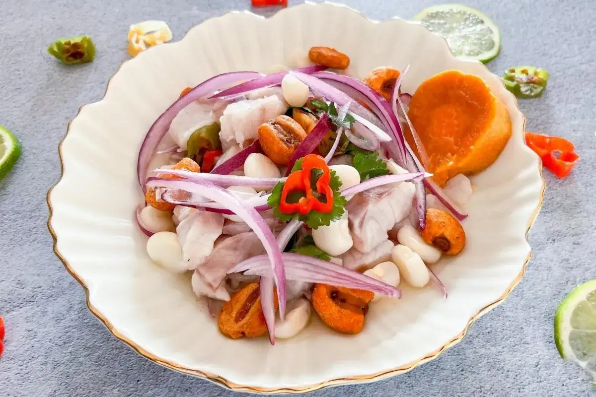 Delicioso ceviche de lubina con camote, choclo, cebolla roja y ají. Un festín de sabores frescos y vibrantes.