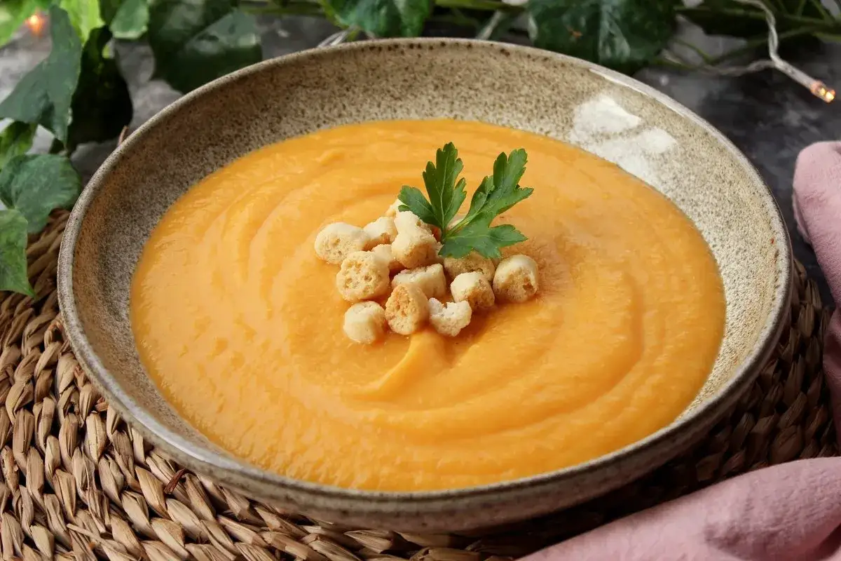 Un reconfortante pure de verduras, adornado con picatostes crujientes y perejil fresco.