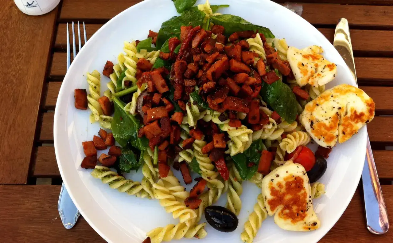 En h&auml;rlig pastasallad med pesto, krispiga bitar, f&auml;rsk spenat och grillad halloumi. En perfekt sommarm&aring;ltid!