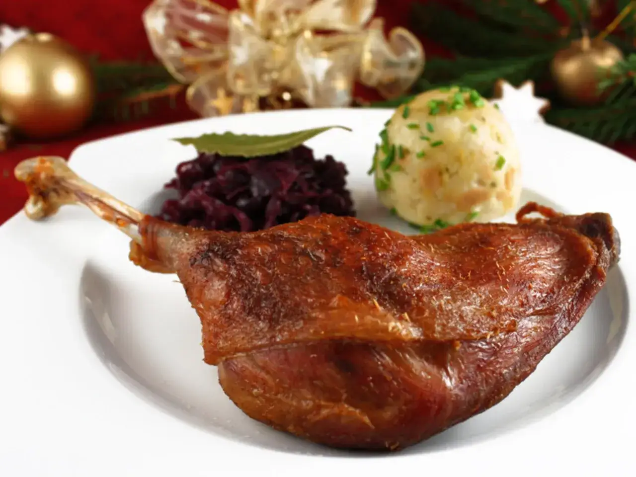 Knusprige Gans mit Rotkohl und Klößen. Ein Festmahl, das nach dem perfekten Wein fragt: welcher Wein zu Gans passt, ist hier die Frage.