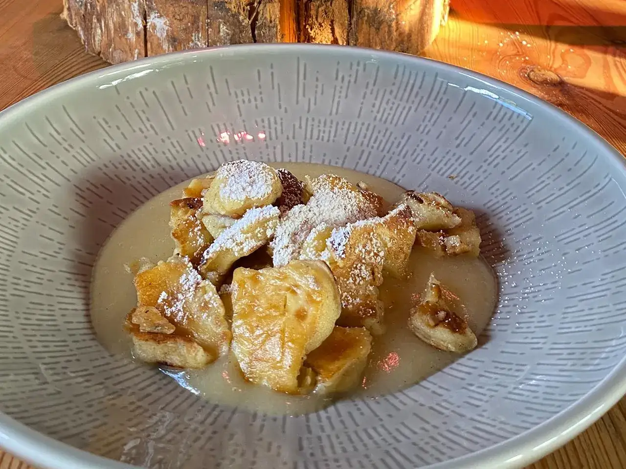 Ein k&ouml;stlicher Kaiserschmarrn, frisch zubereitet nach einem einfachen Rezept, best&auml;ubt mit Puderzucker und serviert in einer stilvollen Sch&uuml;ssel.