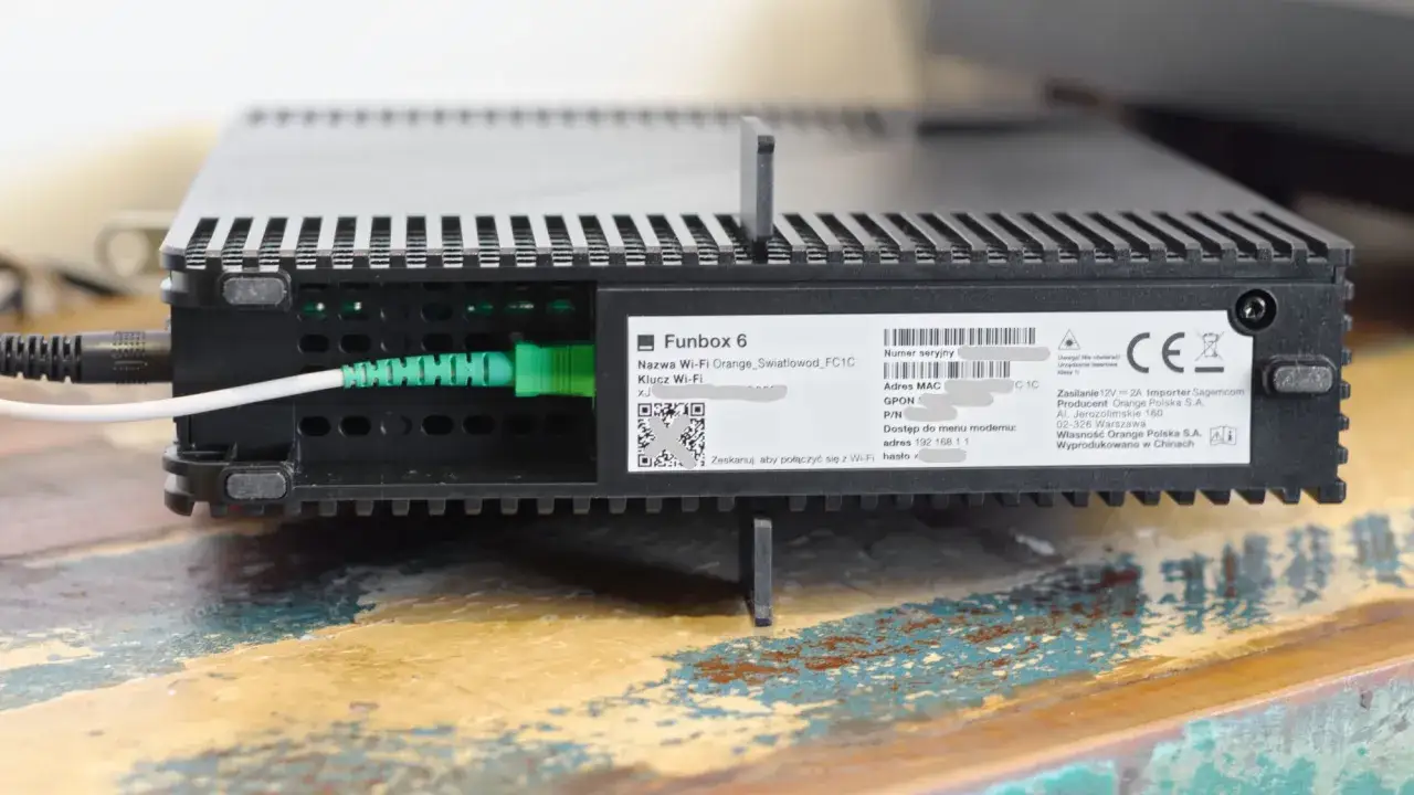 Na routerze Funbox 6 widoczna jest naklejka z danymi. Nazwa Wi-Fi to Orange_Swiatlowod_FC1C, a klucz Wi-Fi (hasło) jest ukryty. Adres do menu modemu to 192.168.1.1.