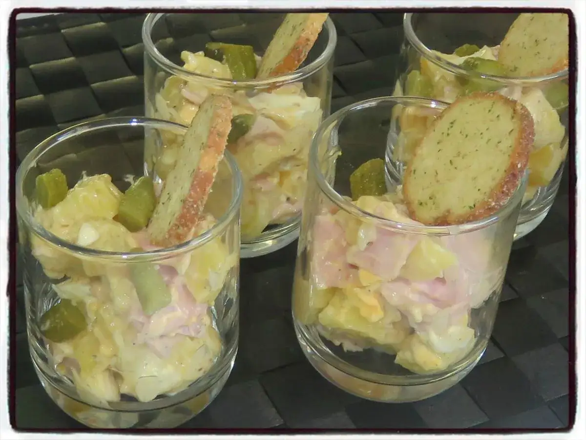 D&eacute;licieuse salade de pomme de terre cr&eacute;meuse, garnie de d&eacute;s de cornichons et d'une tranche de pain grill&eacute; aux herbes.
