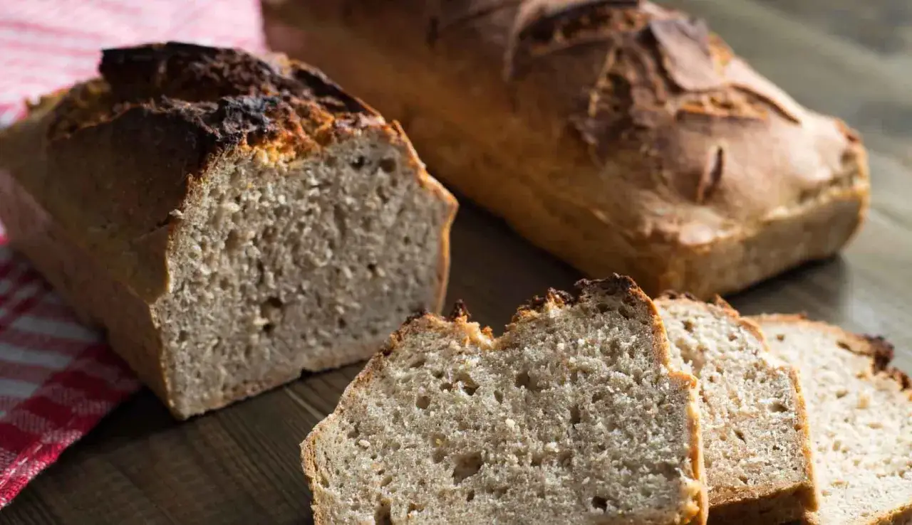 Pane integrale appena sfornato, con crosta dorata e mollica alveolata. Perfetto per una colazione sana.