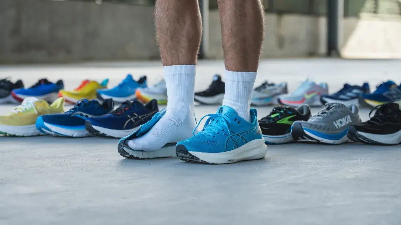 Niebieskie buty do biegania z dużą amortyzacją, obok innych modeli. Idealne na długie dystanse.