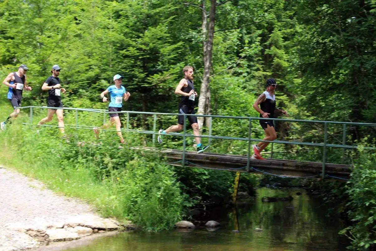 Läufer überqueren eine Brücke während eines x trail breitnau.