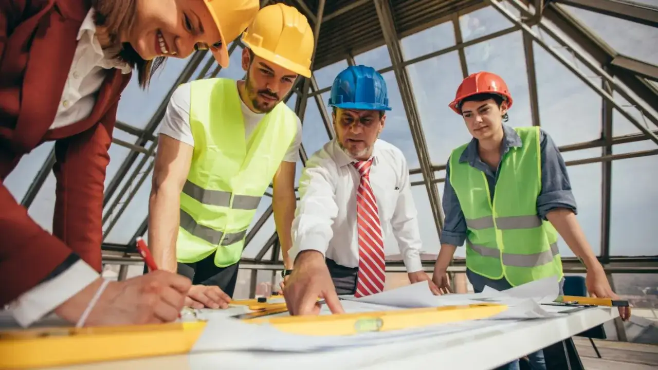 L'architecte et son &eacute;quipe discutent des plans sur un chantier. L'obligation architecte suivi de chantier est essentielle pour la r&eacute;ussite du projet.