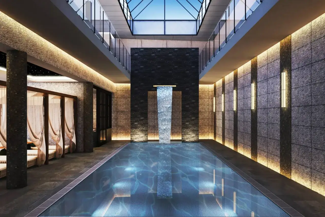 Lyxigt inomhuspoolområde med vattenfall och loungeplatser på AC Hotel Solna.