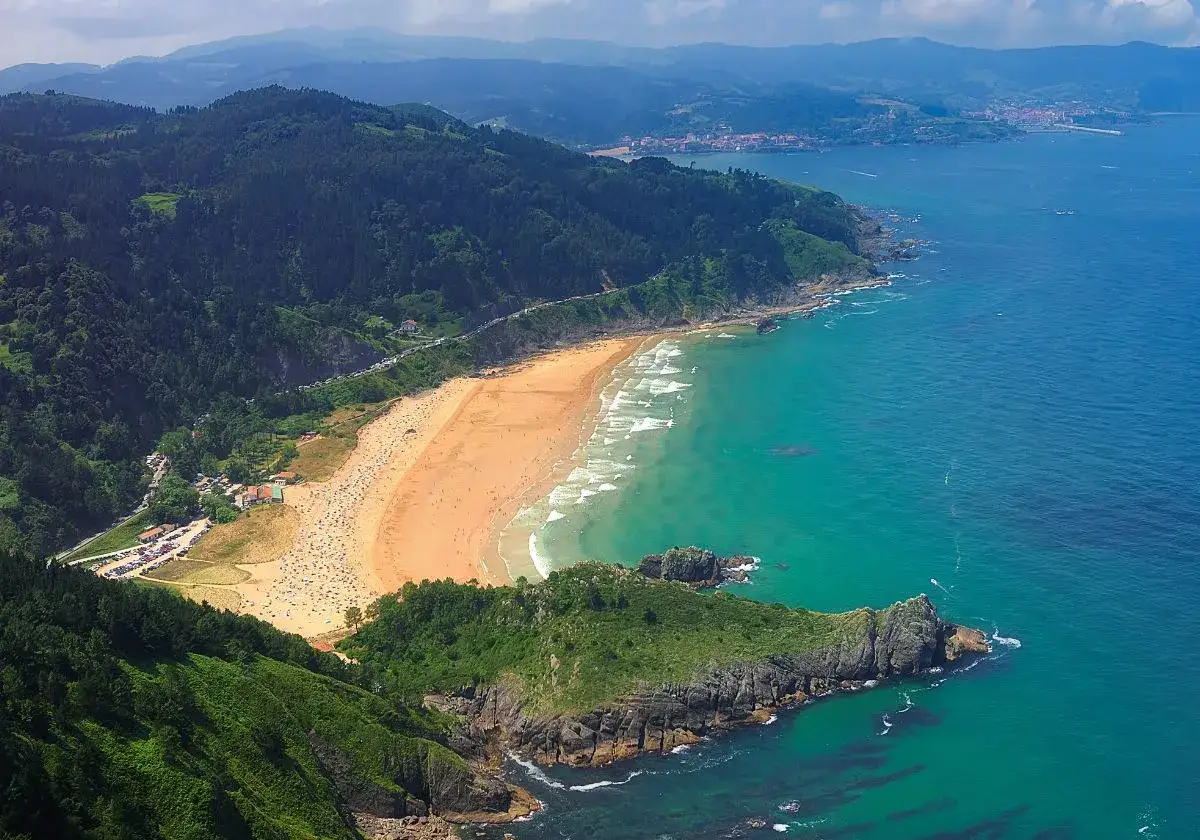 La **playa más cercana a Logroño** es un paraíso de arena dorada y aguas turquesas, rodeada de verdes colinas.