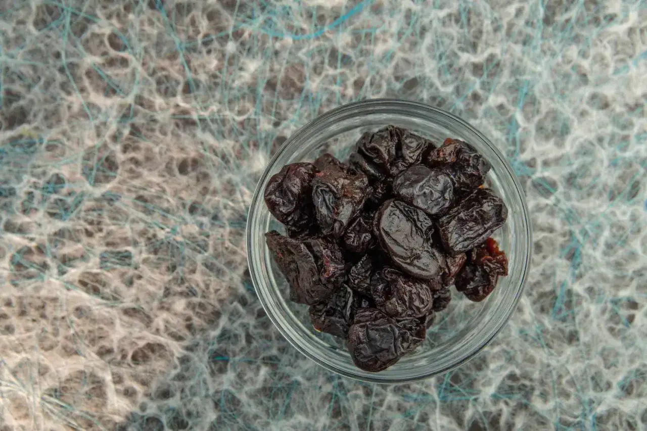 Trockenpflaumen in einer Glasschale. Sie sind reich an Ballaststoffen und können die Verdauung fördern, was eine positive **Boron Wirkung** auf den Körper hat.