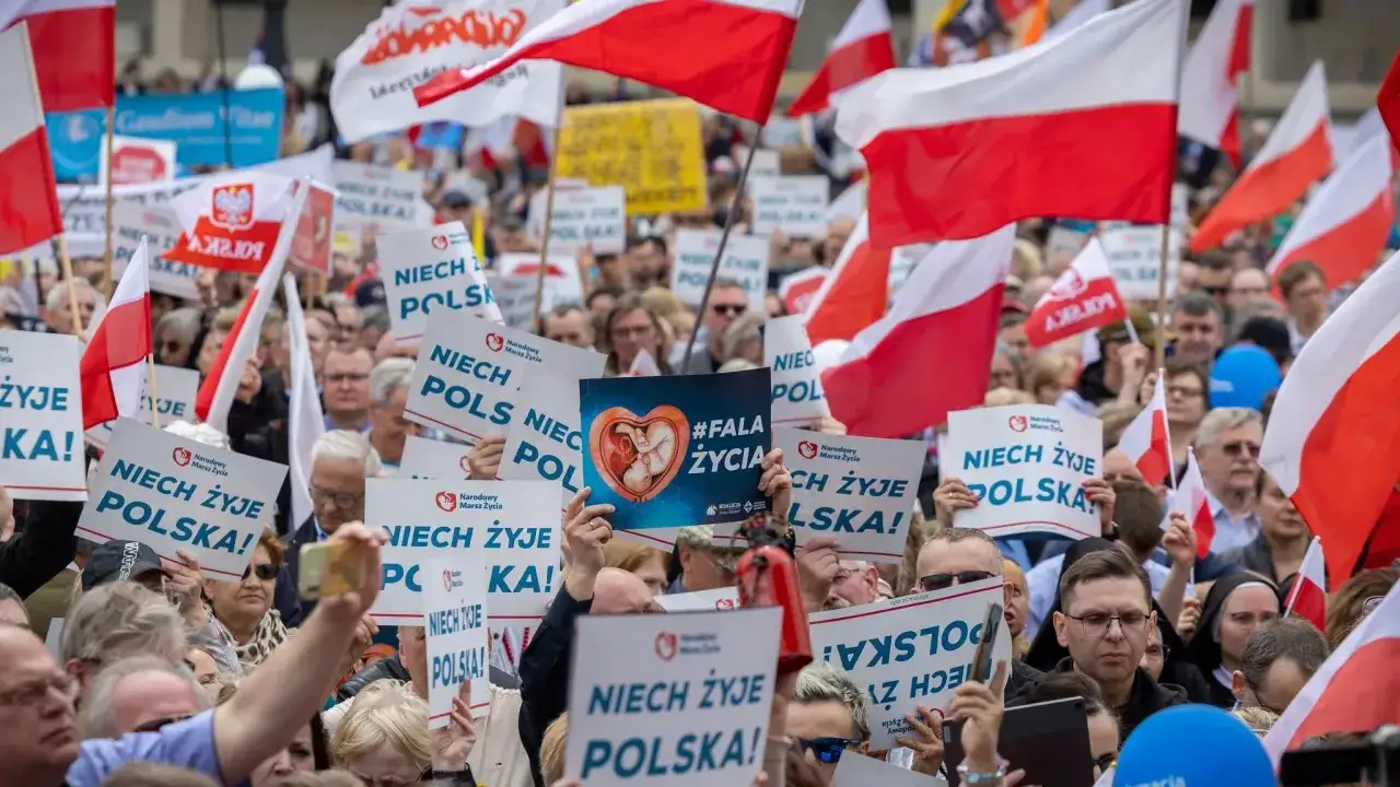 Tłum ludzi z polskimi flagami i transparentami 