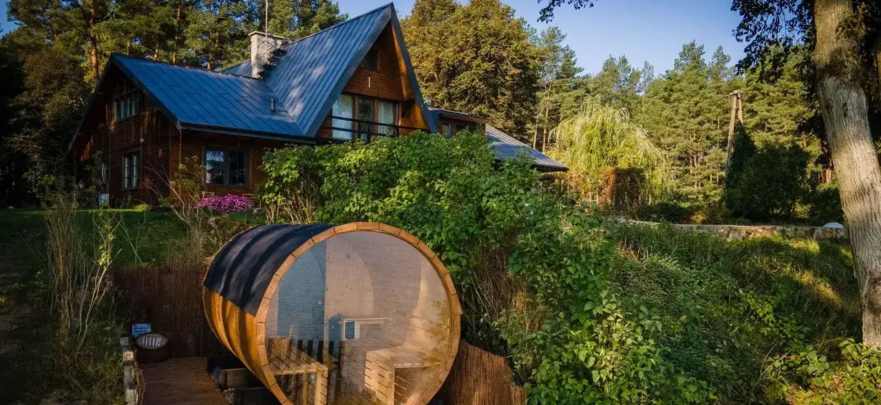 Drewniany domek i beczka sauny nad jeziorem, idealne miejsce na camping w Borach Tucholskich.