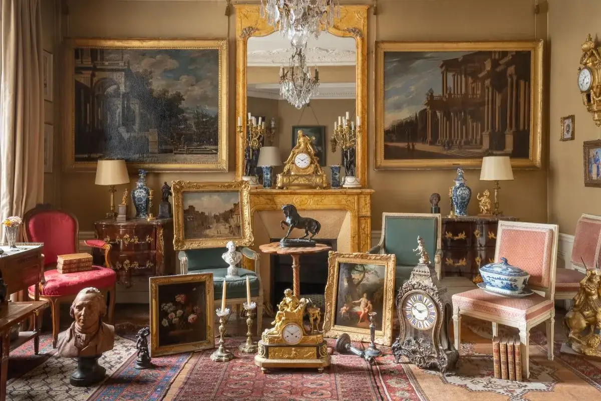Pièces d'antiquités, peintures, horloges et bustes dans un salon. Un inventaire de mobilier de succession est en cours pour estimer le coût.