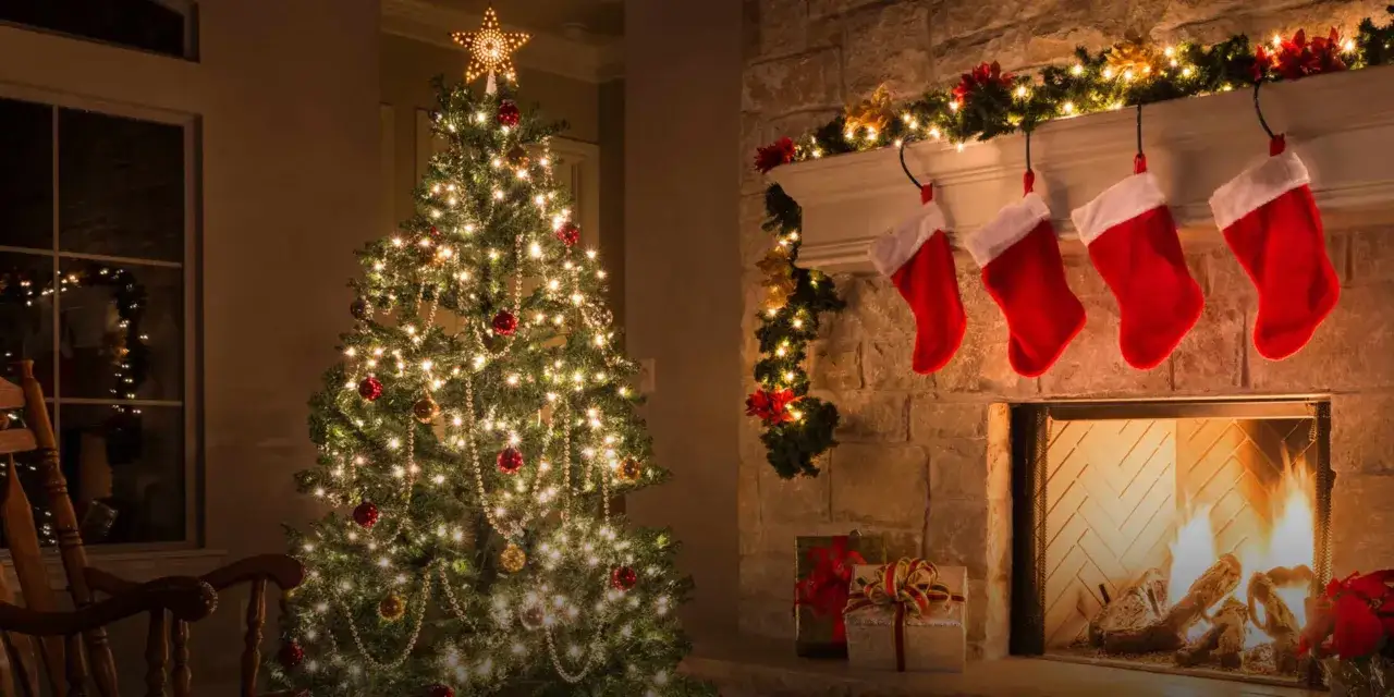 Un albero di Natale illuminato e calde calze rosse appese al camino creano l'atmosfera perfetta per le parole del Natale.