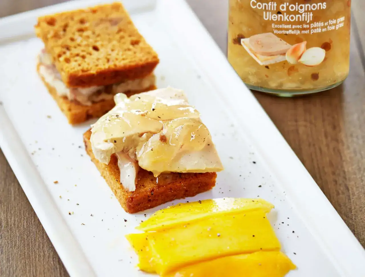 Toast de pain d'&eacute;pice garni de foie gras et de confit d'oignons, accompagn&eacute; de mangue.