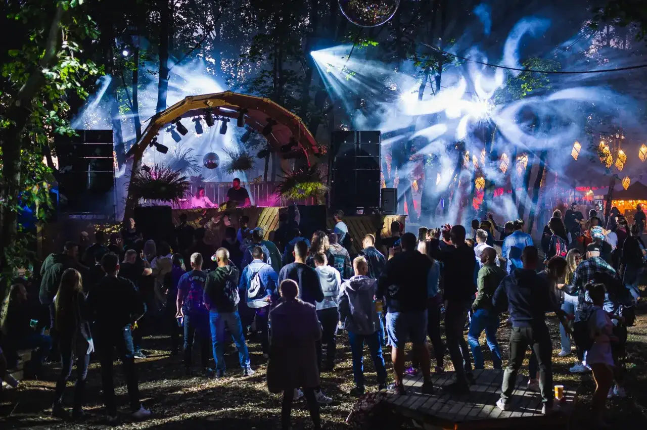 Nocny festiwal w Twierdzy Wisłoujście. Tłum bawi się przy muzyce, w dymie i świetlnych efektach.
