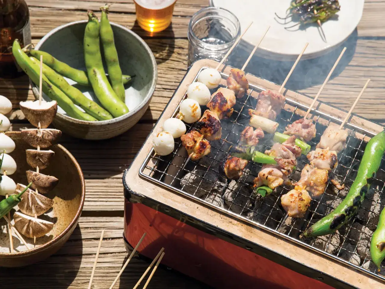Grillowane **yakitori** z kurczakiem i jajkami przepiórczymi, obok miska fasolki i pieczarki na patyczkach.