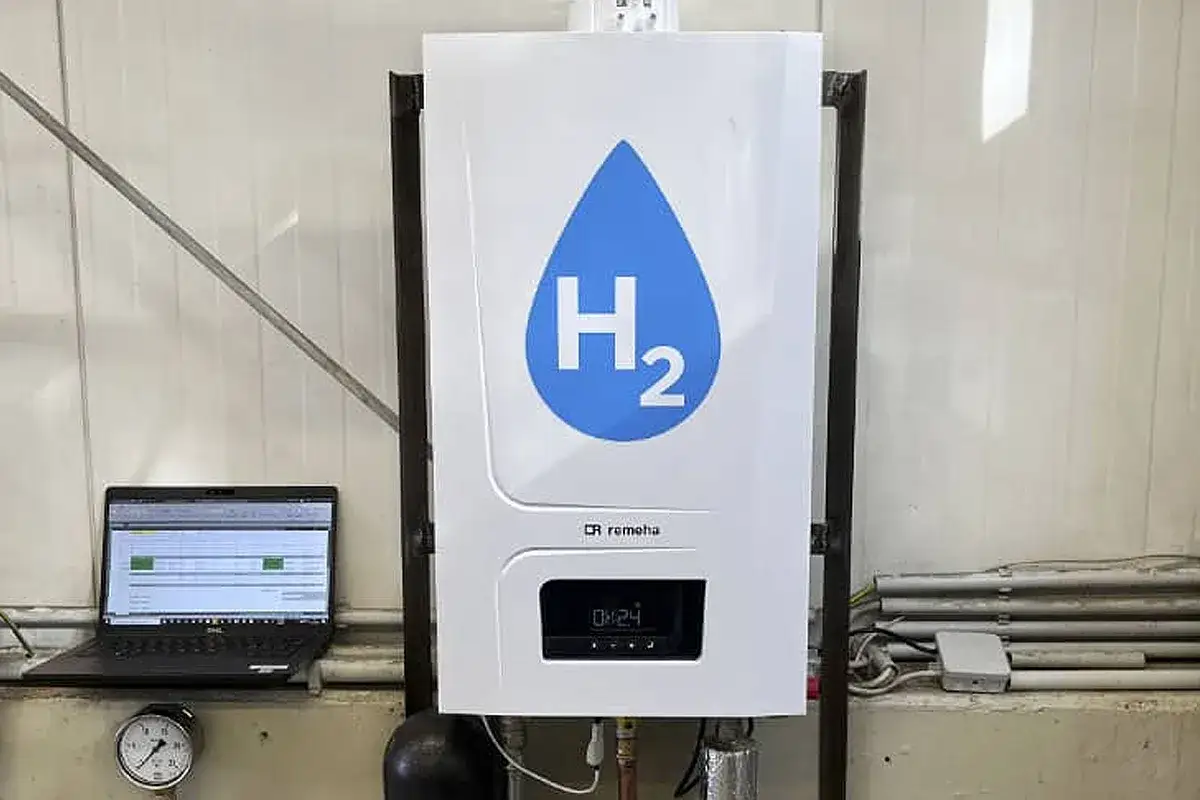 Chaudière hydrogène Remeha avec logo H2. Un ordinateur portable affiche des données de test à côté.