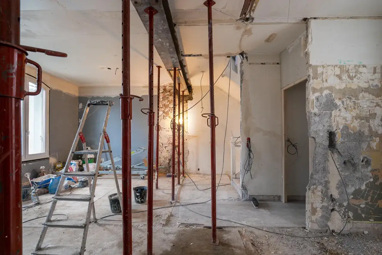 Chantier en cours, &eacute;chafaudages et &eacute;tais soutiennent un IPN. Des marques au mur indiquent sur combien de cm doit reposer un ipn.