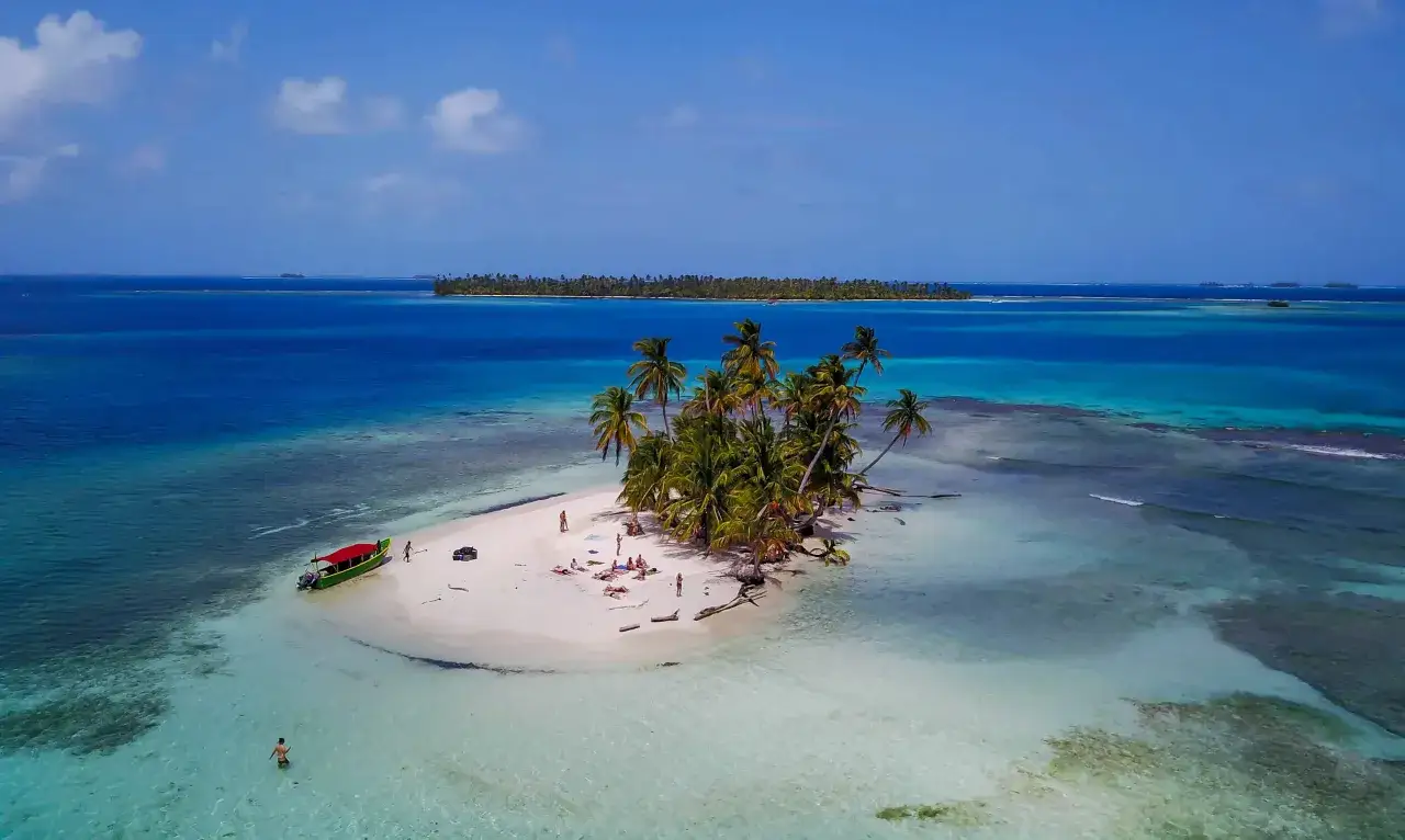 Rajska wyspa z palmami i łodzią, idealna na wakacje. Czy to Seszele czy Mauritius?