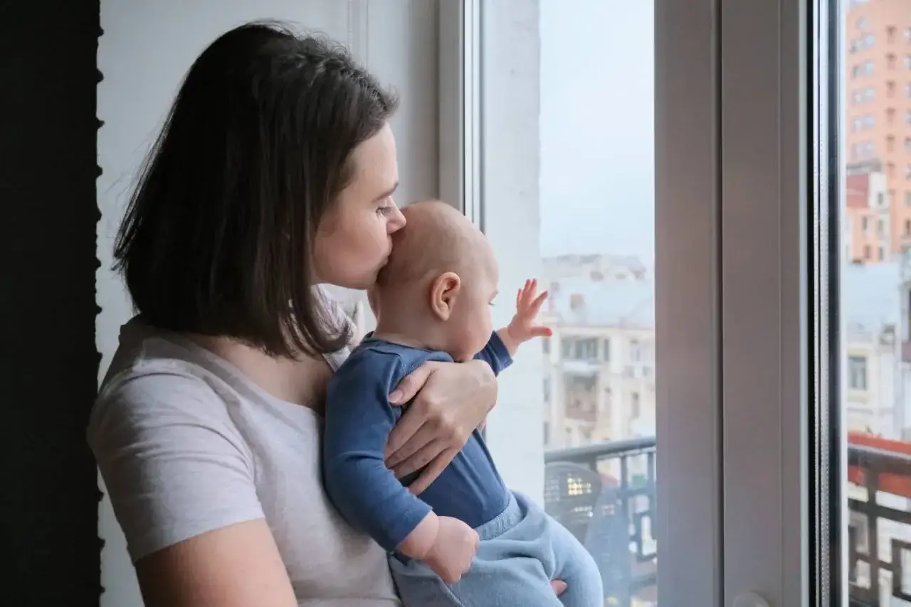 Zmartwiona mama z niemowlęciem na rękach