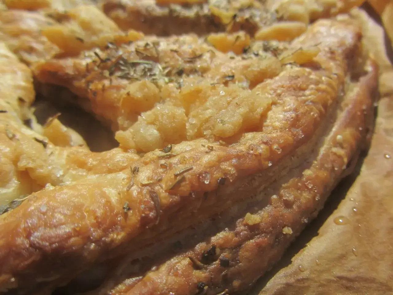 Fougasse aux grattons feuilletée, dorée et croustillante, parsemée d'herbes et de sel. Un délice gourmand !