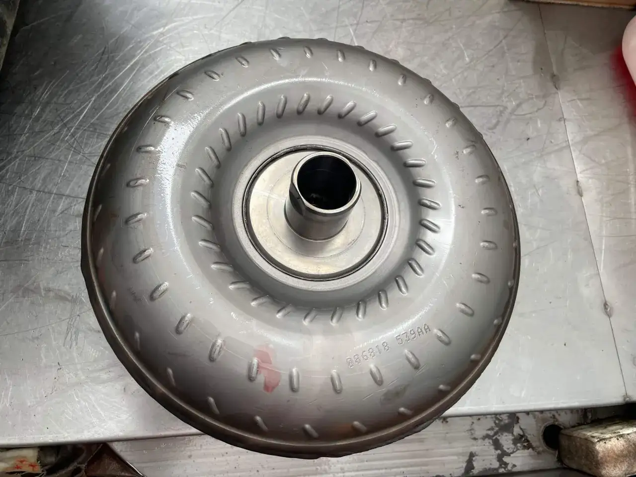 Metalowy element, jeden z rodzajów sprzęgieł, z widocznym numerem seryjnym.