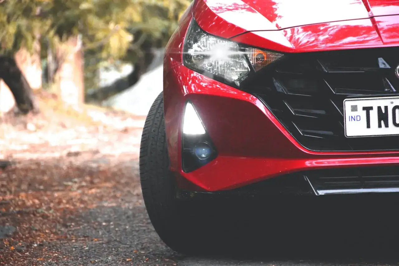 Czerwony Hyundai i20 z zapaloną żarówką do jazdy dziennej, gotowy do drogi.