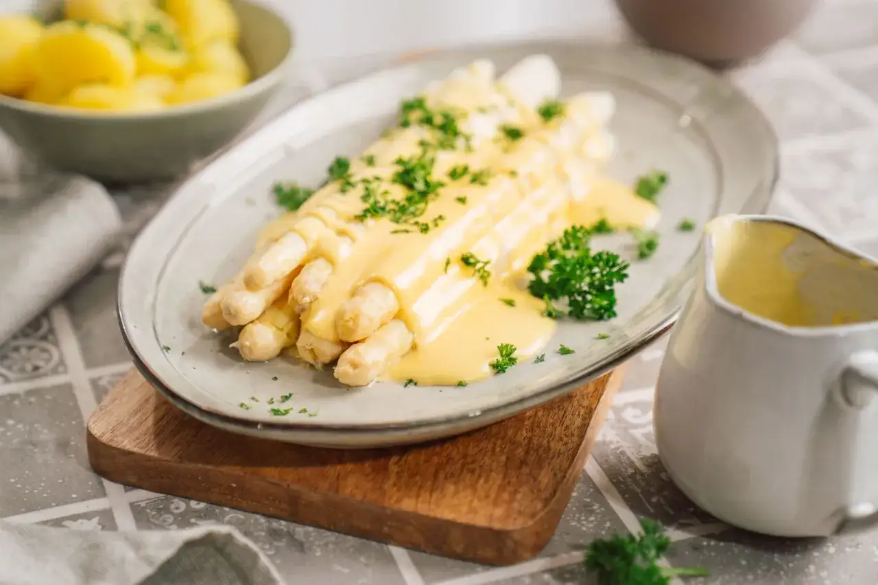 Spargel mit cremiger Hollandaise, garniert mit Petersilie. Ein schnelles blitz hollandaise rezept f&uuml;r den perfekten Genuss.