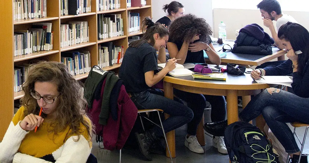Ragazzi a scuola media studiano in biblioteca, immersi in storie e narrativa.