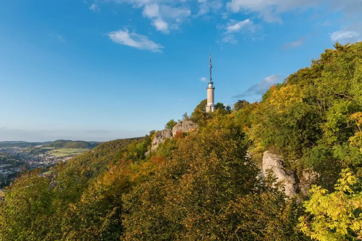 Der Schlossfelsenturm Albstadt ragt auf einem bewaldeten Felsen &uuml;ber der Stadt auf. Bunte Herbstfarben schm&uuml;cken die H&auml;nge.