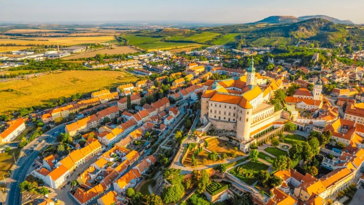 Widok z lotu ptaka na malownicze miasteczko na Morawach w Czechach, z zamkiem g&oacute;rującym nad czerwonymi dachami.