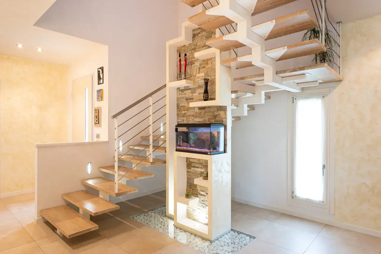 Moderna scala interna in legno e metallo con acquario integrato. Il design innovativo valorizza lo spazio, offrendo un'idea di costo scala interna accessibile per un ambiente unico.