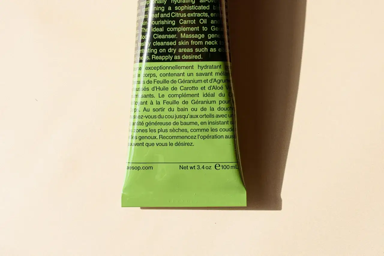 Zielony flakon kosmetyku z tekstem w języku angielskim i francuskim. W składzie mogą występować alergeny w kosmetykach, np. ekstrakty z geranium.